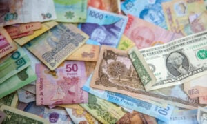 A pile of paper bills representing different currencies