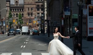 A couple poses for photographs in their wedding outfits during photo shoot in Toronto